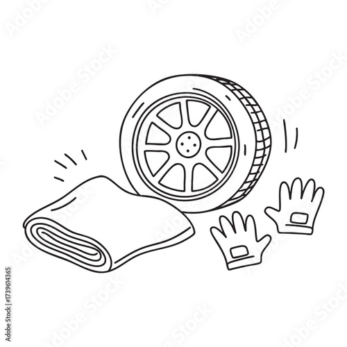 A wheel next to a folded tarp and a pair of gloves