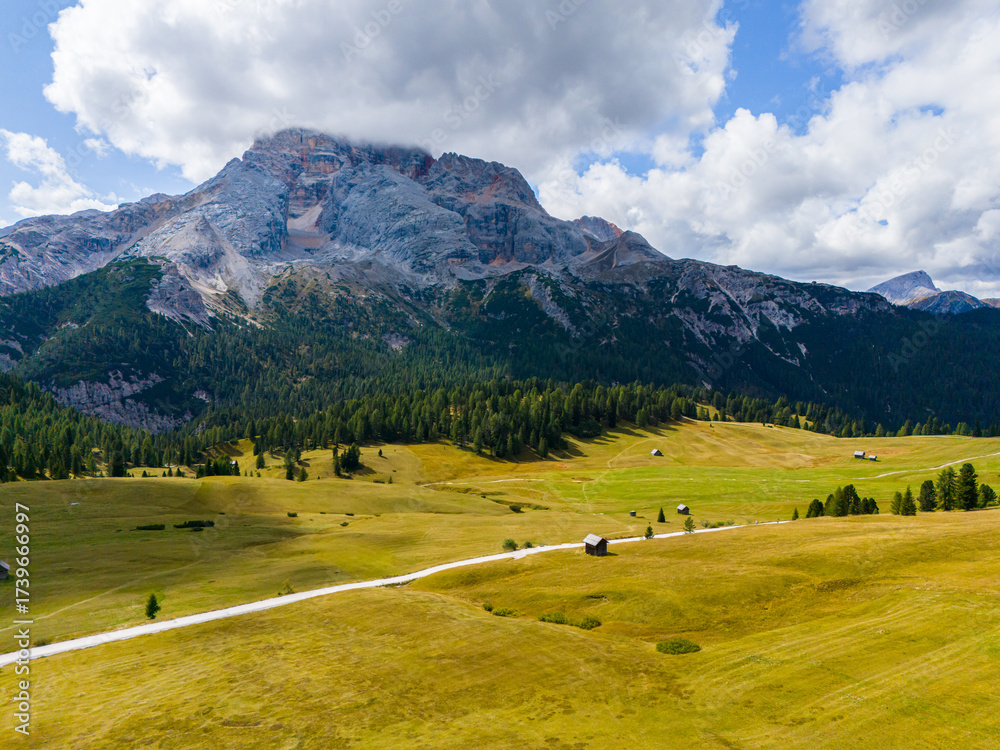Naklejka premium Beautiful landscape in Dolomites, Italy. Malga Prato Piazza meadow and big mountain summit and ridge. South Tyrol region in Italy. Trekking and bike road in Italy Dolomites. Wooden cabin hut.