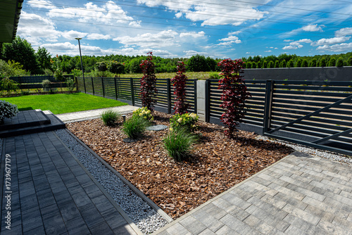 Pine bark lying in the yard in front of the house, visible fence and septic tank.