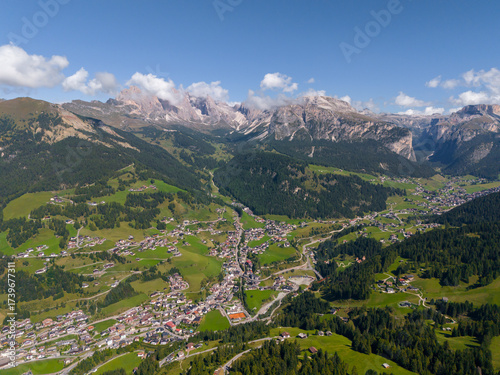 Val Gardena Village Nested Down The Valley Surrounded By The Dolomite Mountain Ranges In South Tyrol, Italy. Aerial Shot. Ortisei in Val Gardena filmed by drone, dense forests and mountain peaks. 