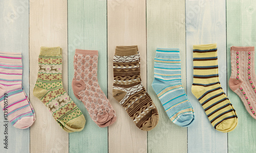 Colorful socks on a multicolored striped background. A panorama of socks for the cold seasons.
