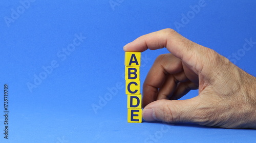 Blocchi di legno con le lettere A, B, C, D, E. Concetto di priorità e gestione delle attività. L'ordine di priorità in qualsiasi attività. Disporre la lista delle cose da fare in verticale.