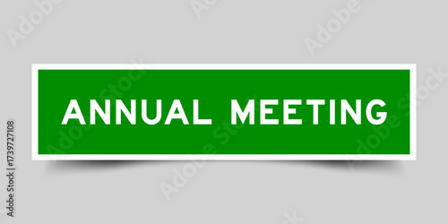 Green color square shape sticker label with word annual meeting on gray background