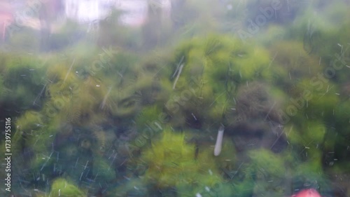 Raindrops fall on a windowsill during a rain. Raindrops on glass. Slow motion.