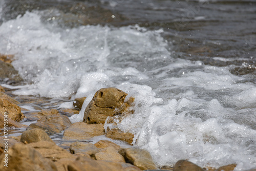 Fototapeta Naklejka Na Ścianę i Meble -  The rough Adriatic Sea in Croatia, waves lapping the stones on the beach Rab Croatia