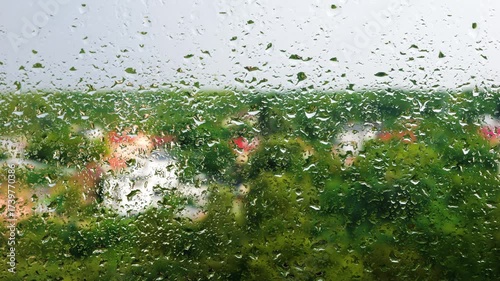 Large raindrops on glass during a rainstorm.