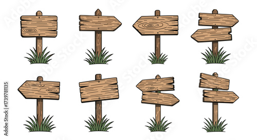 Eight wooden directional signs on posts surrounded by grass.