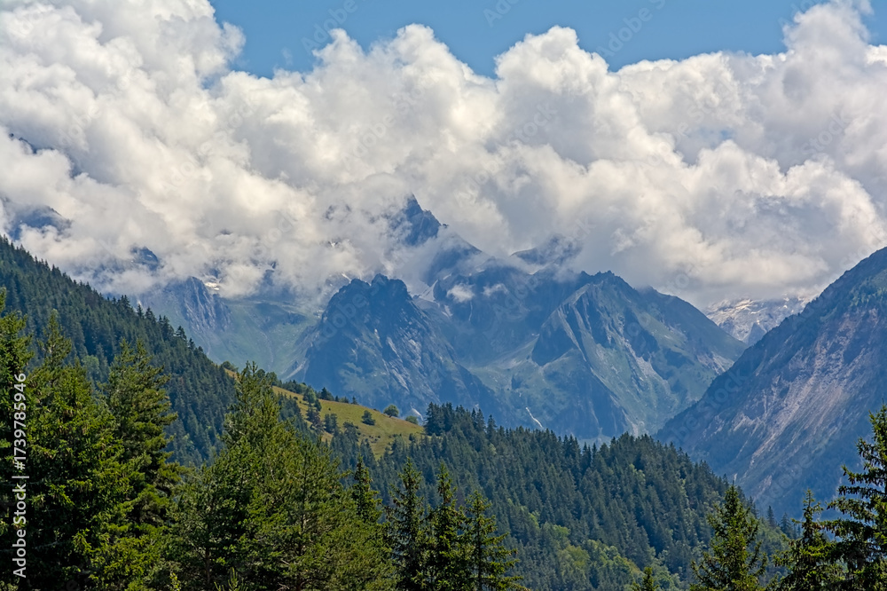 Fototapeta premium Clouds over mountains and valleys with forest in La Vanoise national park, Savoie, France 