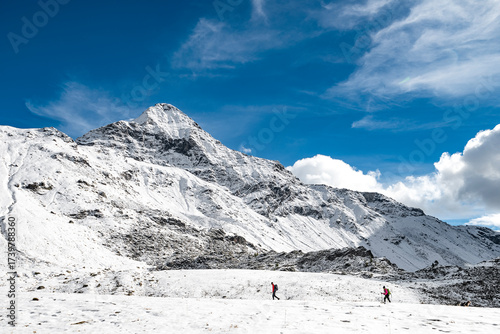 Hiking on snow with Pizzo Scalino on background, Central Alps, Italy landscape