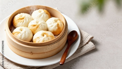 Fluffy steamed bao buns in a bamboo steamer on a warm wood table—soft, cloud-like dim sum ready to serve.

