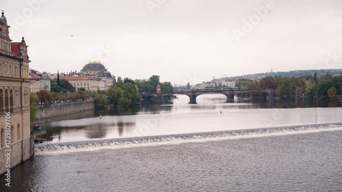 Stunning sunrise over Prague with warm golden light illuminating historic architecture, cobblestone streets, and iconic city landmarks in high-quality detail.