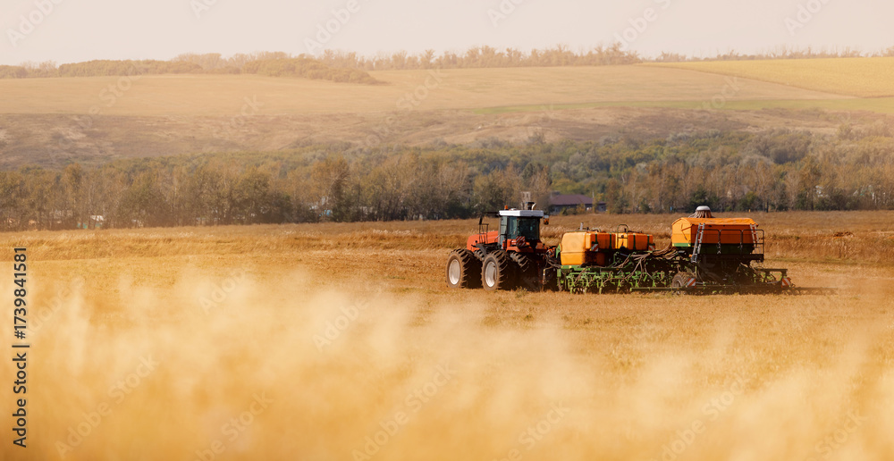 Fototapeta premium Tractor cultivating field in rural countryside landscape
