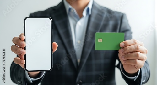 Businessman Holding Smartphone and Green Credit Card, Blank Screen, Close-Up Shot.