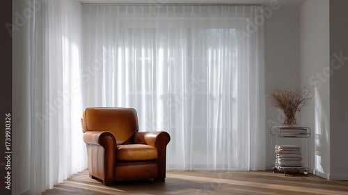 Nice photo of comfortable leather armchair in a bright living room with sheer curtains.