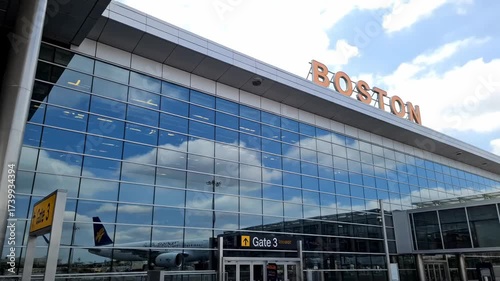 Boston Airport exterior reflection of a plane on glass building with the city skyline visible
