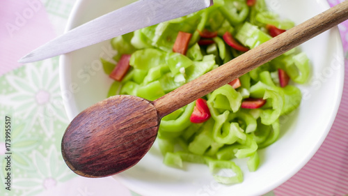 Freshly chopped vegetables with a wooden spoon and knife