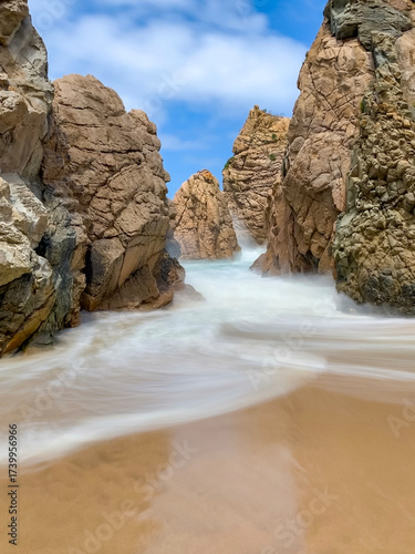 Canvastavla Ursa beach near Cabo da Roca features rugged cliffs, golden sand, and crashing waves under a clear blue sky
