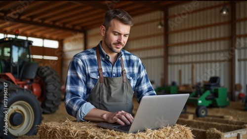 Modern Farmer Using Laptop in Agricultural Barn Setting