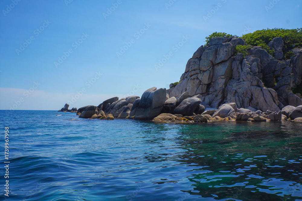Obraz premium Majestic Rocky Cliffs Rising Above the Clear Turquoise Sea
