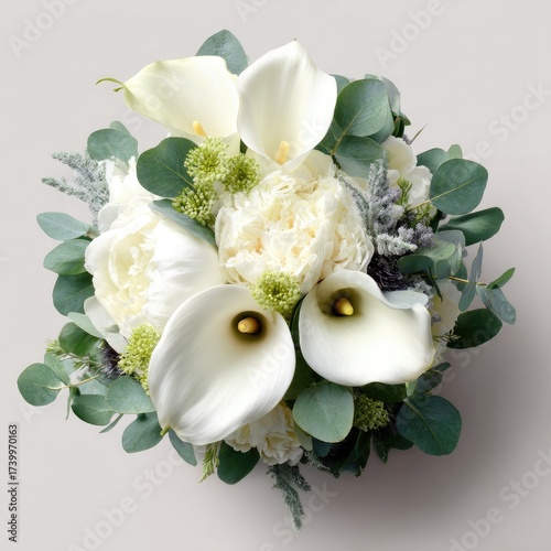 Overhead view of a bridal bouquet featuring calla lilies, peonies, and greenery on beige