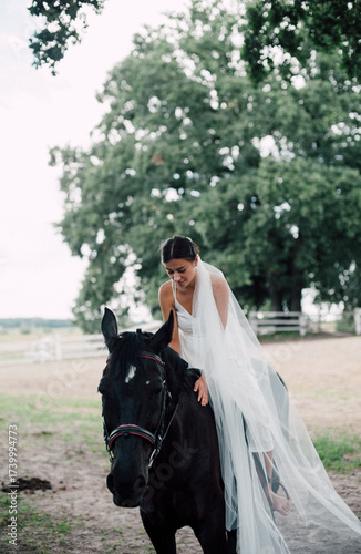 Bride riding horse in wedding dress outdoors
