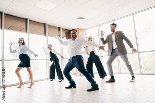 Team of business professionals enjoying a lively group activity together in a modern office environment