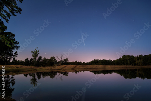 A Comet At Williams Lake with calm water reflections at dusk and blue hour