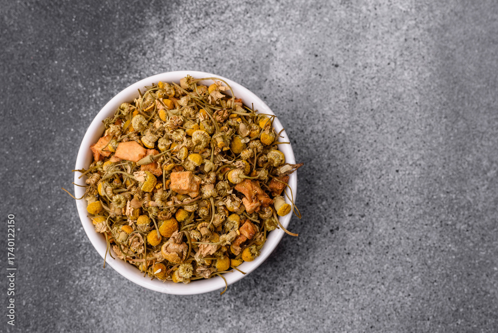 Fototapeta premium Dried chamomile flowers, herbal tea in a bowl for a hot morning drink. Dried chamomile