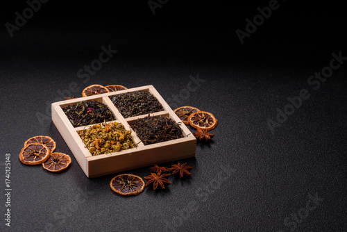 A wooden box with several types of dried tea, green, black, fruit, and chamomile. Dry tea in the box