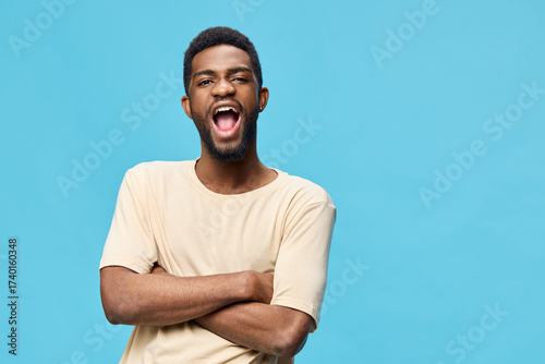 Quadro su tela A joyful young African man smiling against a bright blue background, showcasing