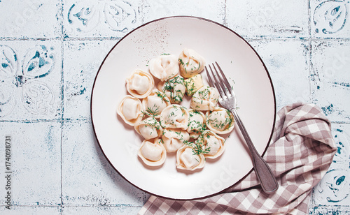 homemade dumplings, on a plate, with herbs on a rustic table