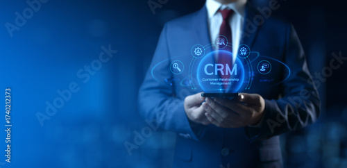 Businessman holding smartphone with CRM Customer Relationship Management icons on screen