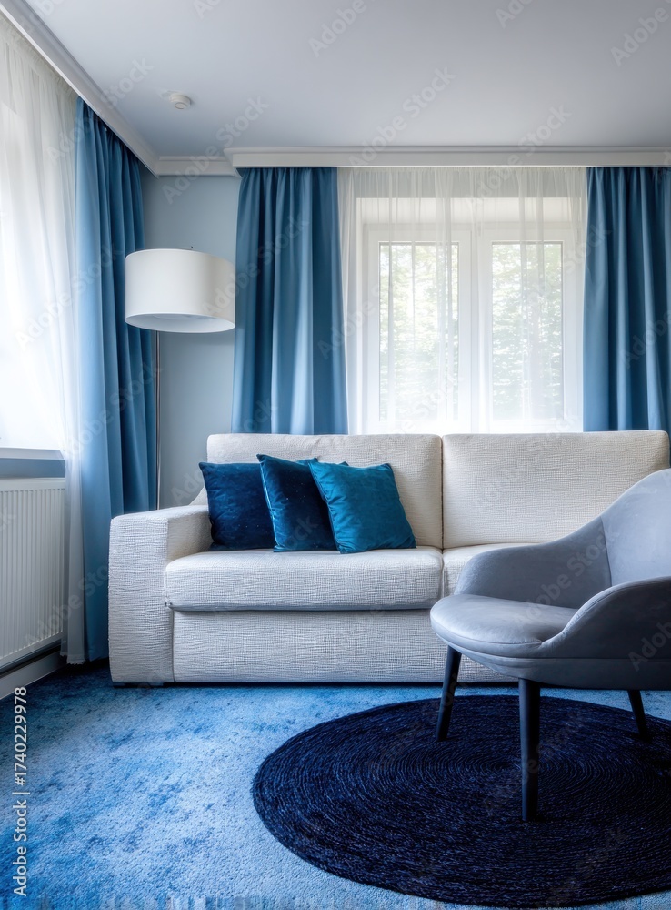 Fototapeta premium A bright living space with blue curtains and rug, light-colored sofa and a round rug