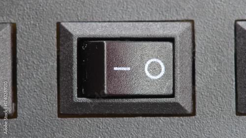 Finger pressing a two way on off switch turning off a generic electrical appliance electronic device power control button macro closeup detail saving energy simple abstract concept symbol one person