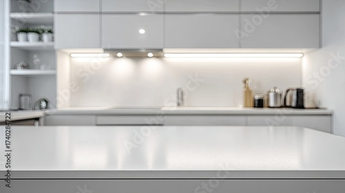 Blurred modern kitchen interior.  Light gray cabinets, countertop, and backsplash.  Soft lighting.  Minimalist style.  Focus on countertop
