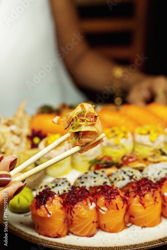 Large sushi plate with different types of rolls in warm and pastel tones. Asian food. Oriental Brazilian restaurant.