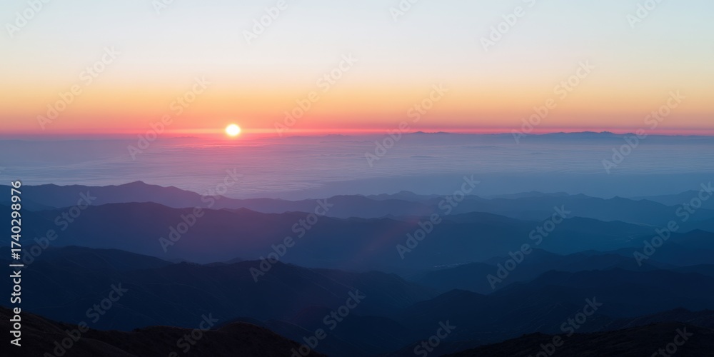 Naklejka premium Sunrise illuminating mountain ranges and clouds in a layered landscape