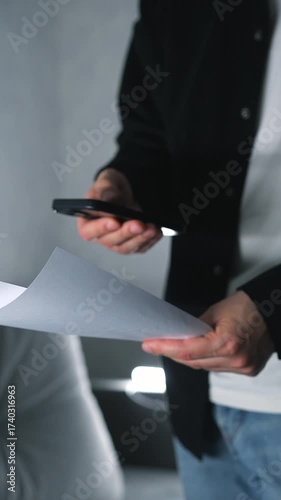 A man scans paper documents with a smartphone camera to access information.
Paper receipts and a man with a smartphone taking a photo of the information.
Information, payment, receipt, phone, paperwor