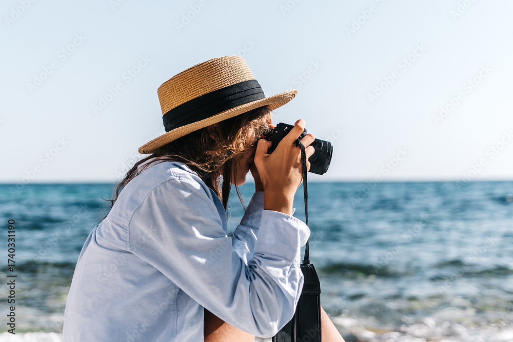 Obraz premium Woman, camera, ocean. A woman photographs the scenic view while relaxing at the beach, enjoying summer travel.