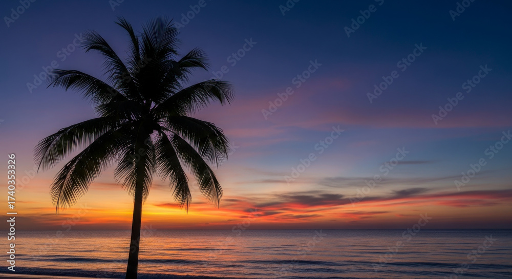 Obraz premium Silhouette of a Palm Tree Against a Vibrant Tropical Sunset Over the Ocean
