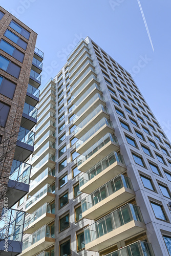 Low-angle view of building facade against a light teal sky, showcasing modern architecture and design, urban, London, United Kingdom, 8 March 2025