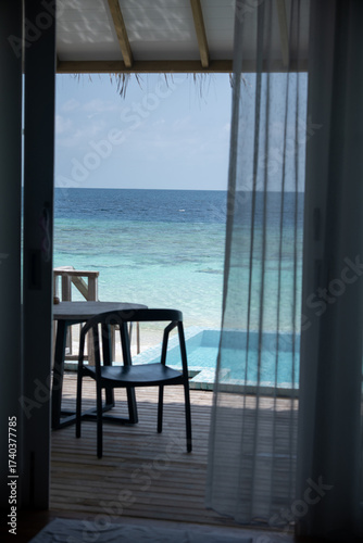 Ocean view from resort villa with chairs and pool