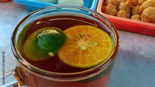 A cup of warm orange tea with a refreshing citrus aroma and a soothing golden color. The tea blends the natural sweetness of oranges with the comforting warmth of freshly brewed tea, creating a relaxi