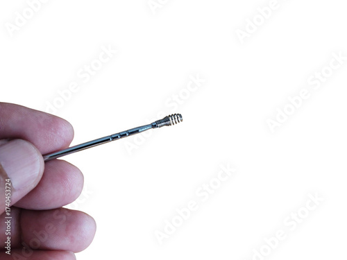 A hand holding ears pick metal, on a white background.
