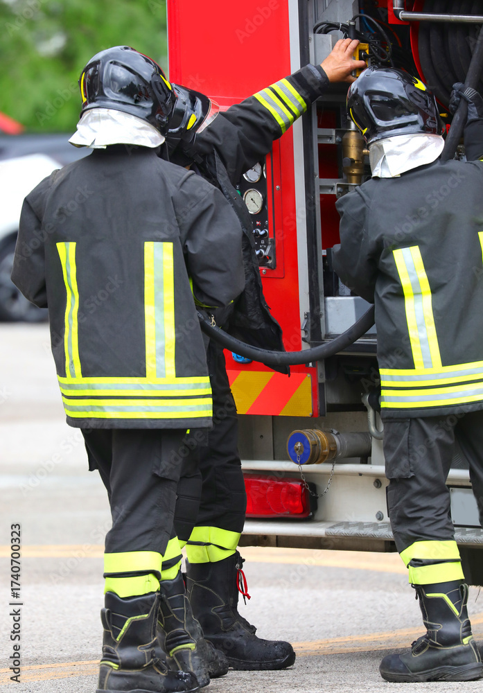 Naklejka premium firefighters during an emergency situation and the fire truck