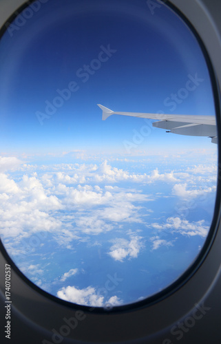 airplane wing with clouds from a commercial plane window ideal as a travel concept