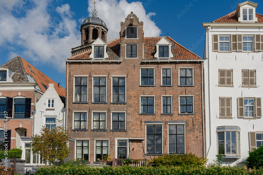 Fototapeta premium Historical buildings featuring traditional architecture with orange tiled roofs under a partly cloudy sky.