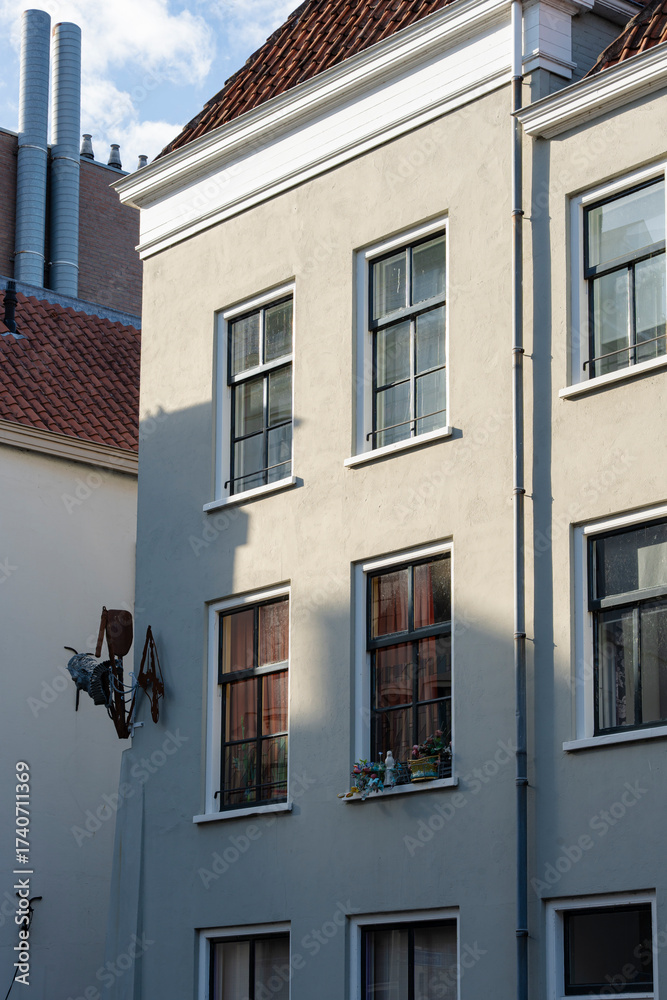 Obraz premium Exterior of an old European building with windows, a tiled roof, and artistic touches on the building.