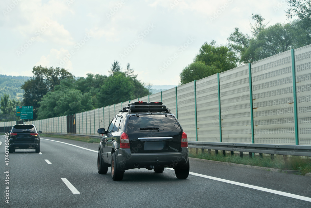 Fototapeta premium Car driving with rooftop storage on highway