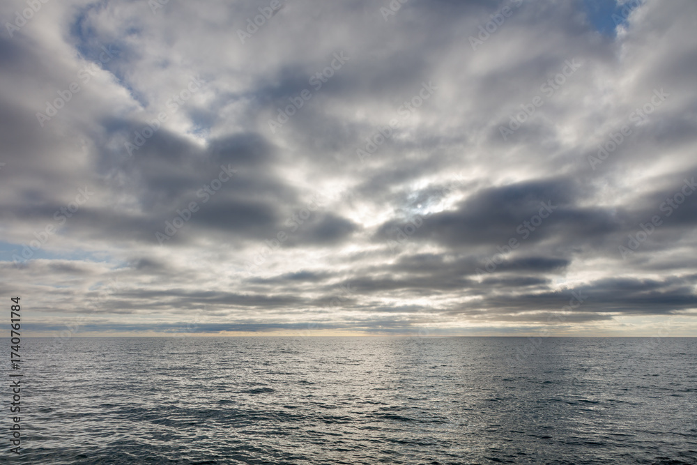 Obraz premium The sky is cloudy and the ocean is calm